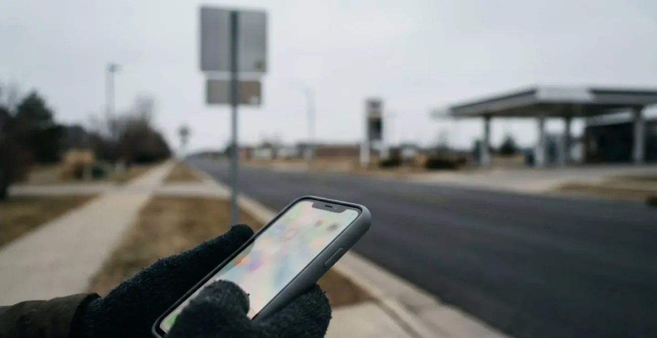 Vue en contre-plongée d'un smartphone montrant une carte GPS avec localisation de stations-service environnantes