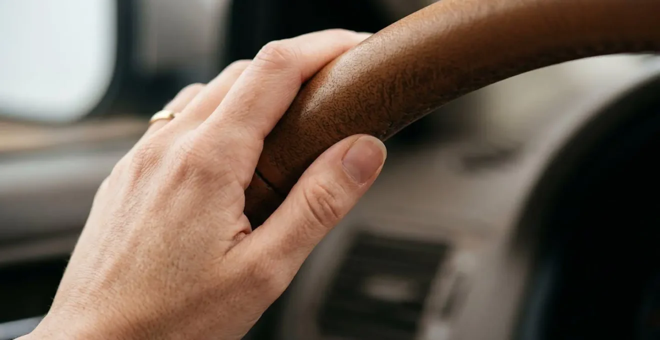 Gros plan sur les mains d'un conducteur adoptant une conduite souple avec éclairage naturel doux
