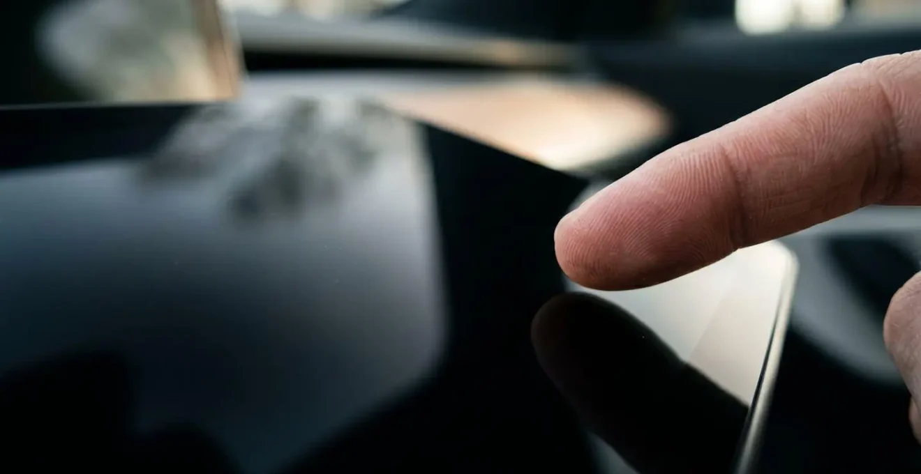 Gros plan sur une main interagissant avec un écran tactile de voiture moderne