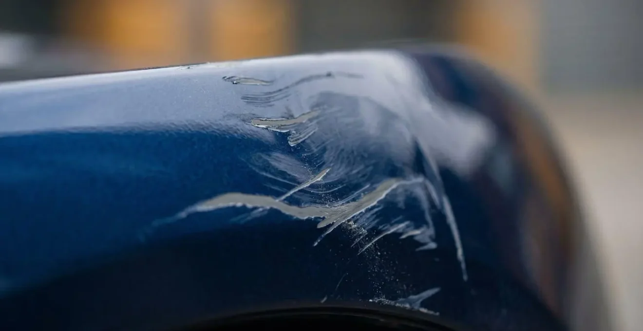 Détail macro de rayures sur carrosserie automobile nécessitant réparation